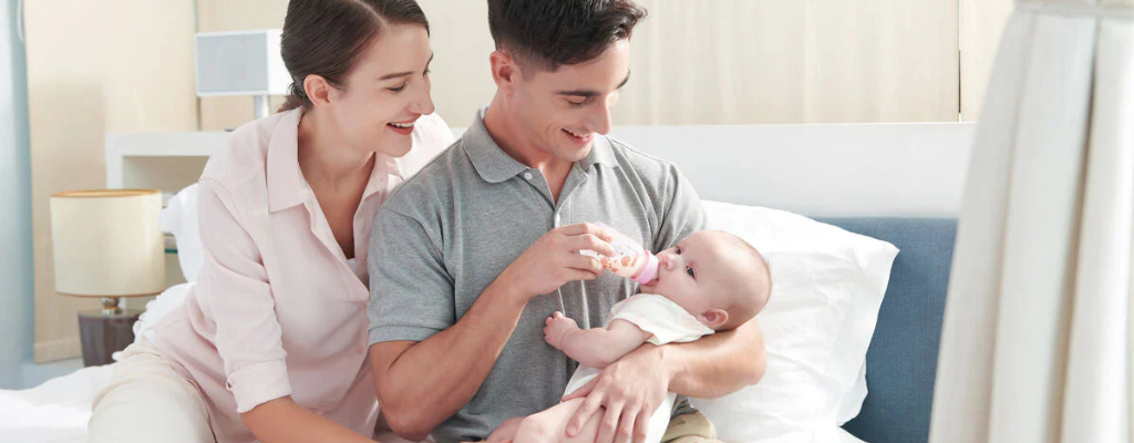 parents feeding baby with a bottle