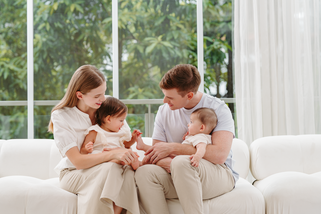 parents holding baby and toddler on lounge