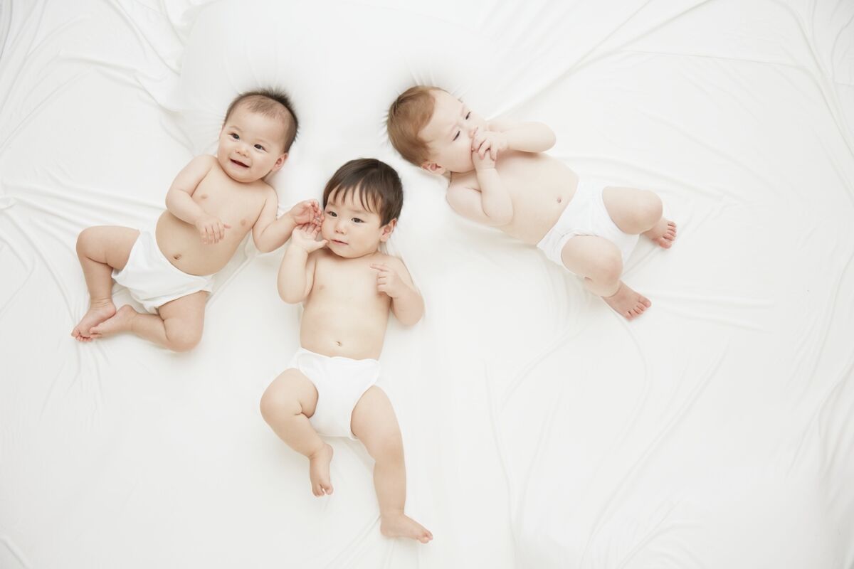 happy babies laying on bed