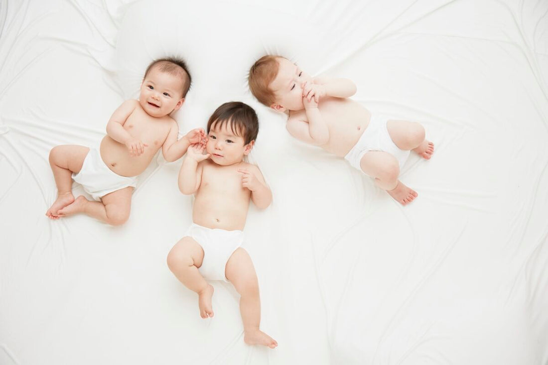 happy babies laying on bed