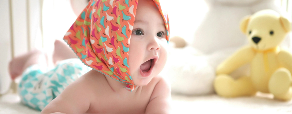 baby wearing bandana in a cradle