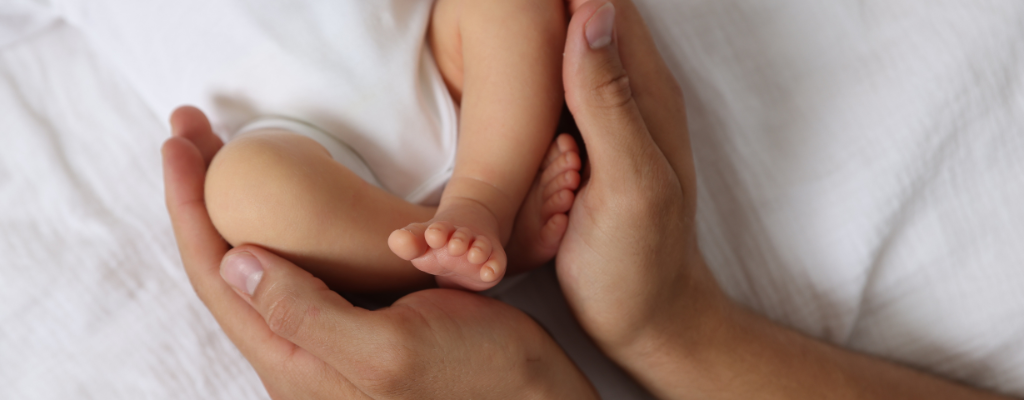 mother holding baby feet