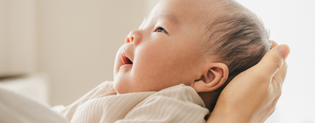 Parent gently cradling a newborn baby