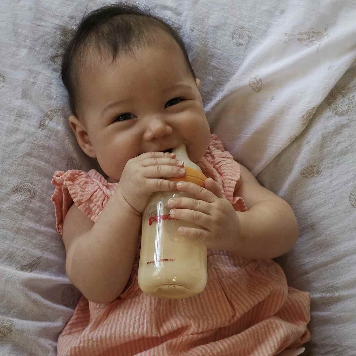 baby holding slow flow baby bottle